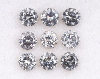 May include: Nine round-cut diamonds arranged in a grid pattern. The diamonds are colorless with visible inclusions, reflecting light. The gemstones are set against a white background, highlighting their brilliance and clarity. Ideal for jewelry making.