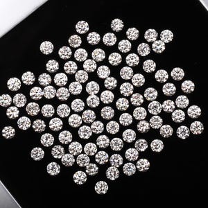 May include: A collection of round, brilliant-cut diamonds on a black surface. The diamonds are clear and sparkling, reflecting light. The arrangement is dense, showcasing the facets and brilliance of each stone.