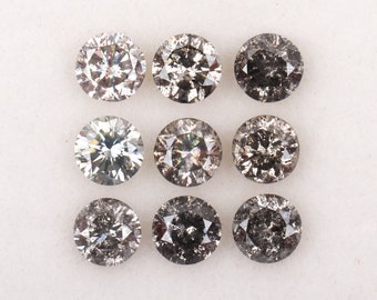 May include: Nine round, faceted, black diamonds with a hint of grey. The diamonds are arranged in three rows of three.