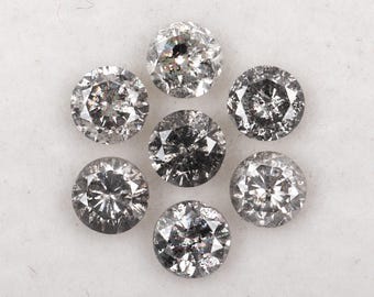 May include: Seven round-cut, salt and pepper diamonds arranged in a circular pattern. The diamonds are a mix of gray and clear, with visible inclusions. The facets catch the light, creating a sparkling effect. Ideal for jewelry making.