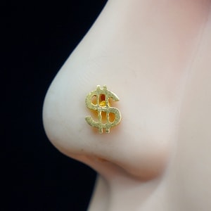 May include: Gold nose ring with a dollar sign design.