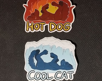 May include: Two die-cut stickers. The top sticker features a brown dog in flames with the text "HOT DOG". The bottom sticker shows a blue cat in ice with the text "COOL CAT". Both stickers have a white border.