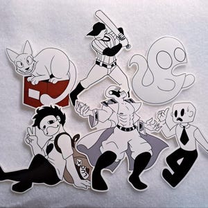 May include: A collection of white and black cartoon stickers featuring various characters. Includes a cat on a box, a baseball player, a ghost, a figure with a cape, a person with a mask, and a person in a suit.