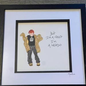 May include: Framed artwork featuring a watercolor illustration of a person with red hair, wearing a black shirt, tan coat, and striped pants. The artwork includes the handwritten text "But I'm a Creep I'm a Weirdo" and is signed "Moonface".