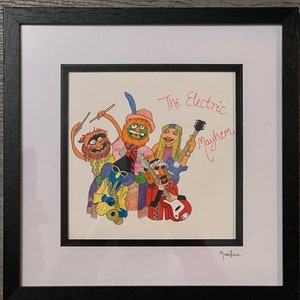 Puede incluir: Una ilustración enmarcada de una banda llamada "The Electric Mayhem" con cinco personajes de los Muppets tocando instrumentos musicales. Los personajes son Animal, Scooter, Dr. Bunsen Honeydew, Beaker y Janice. La ilustración está firmada "Moonface".