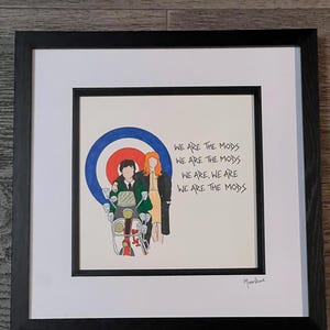 May include: A framed illustration of two people riding a scooter with a target symbol behind them. The text "WE ARE THE MODS" is repeated four times in a handwritten style.