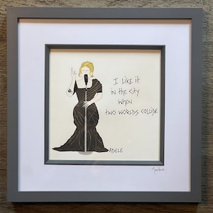 May include: A framed illustration of a woman singing into a microphone. The text in the image reads "I like it in the city when two worlds collide" and "Adele".