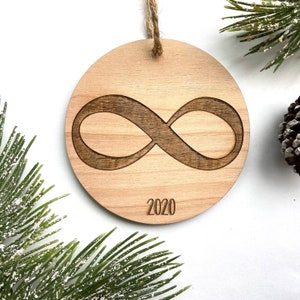 May include: A wooden Christmas ornament with an infinity symbol and the year 2020 engraved on it.