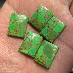 May include: Five green turquoise cabochons with gold flecks. The cabochons are rectangular and have a smooth, polished surface.
