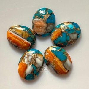 May include: Five oval-shaped cabochon gemstones with a mix of turquoise, orange, white, and gold colors. The stones are smooth and polished.