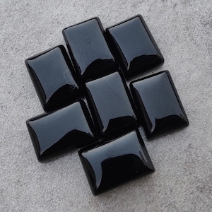 Op de afbeelding: Een set van acht zwarte rechthoekige glazen tegels. De tegels zijn glad en glanzend.