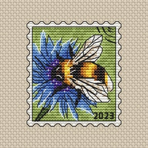 May include: A green and white postage stamp with a bee on a blue flower. The year 2023 is printed on the stamp.