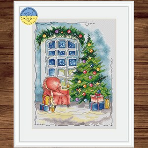 May include: A cross-stitch pattern of a cozy living room scene with a red armchair, a decorated Christmas tree, and a window with a view of a starry night.