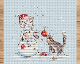 May include: A white cat wearing a red and white hat and mittens is building a snowman. A gray cat with a bow tie is looking at a red Christmas ornament.