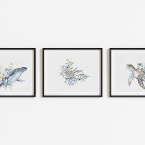 May include: Three framed watercolor illustrations of ocean animals with floral accents. The first image features a blue whale with white flowers. The second image features a floral bouquet with blue and green hues. The third image features a sea turtle with blue flowers.