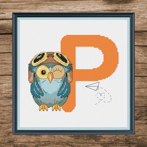 May include: Cross stitch pattern featuring a cartoon owl wearing aviator goggles and a hat, next to the letter P in orange. The owl is winking and a paper airplane is flying in a circle around the letter.