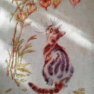 Könnte beinhalten: Kreuzstich-Stickerei eines braunen Tabby-Katers, der sitzt und zu einem Zweig mit orangefarbenen und gelben chinesischen Laternen aufblickt.