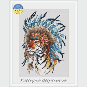 Può includere: Uno schema di punto croce di una tigre che indossa un copricapo blu e marrone con piume. La tigre guarda a sinistra. Il testo "Kateryna Besperstova" è in basso nell'immagine.