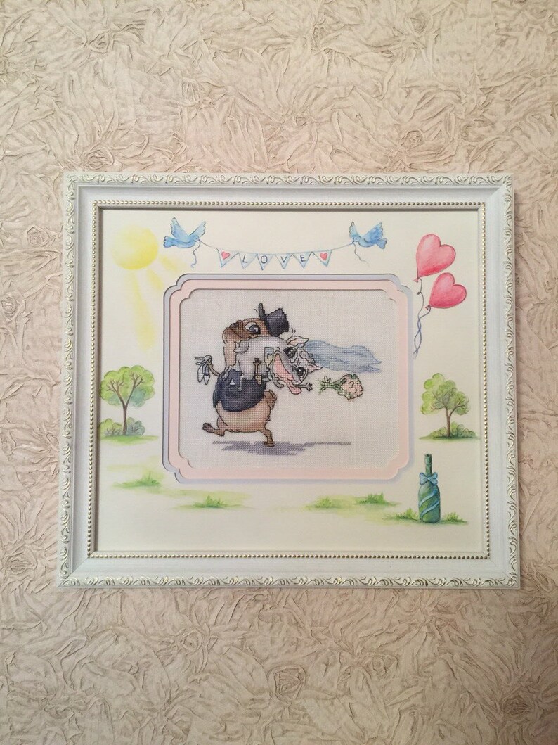 Peut inclure: Une broderie au point de croix encadr&eacute;e repr&eacute;sentant une sc&egrave;ne de mariage de dessin anim&eacute; avec deux animaux, un lapin et un renard, v&ecirc;tus d'une tenue de mariage. La broderie est entour&eacute;e d'un cadre blanc avec une bordure d&eacute;corative. L'arri&egrave;re-plan comprend un soleil, des oiseaux bleus et une bouteille de champagne.