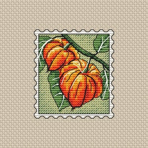 Könnte beinhalten: Ein Kreuzstich-Design einer Briefmarke mit zwei orange-roten Lampionfrüchten. Die Früchte befinden sich an einem grünen Stiel mit grünen Blättern. Die Briefmarke hat einen weißen Rand mit einem gezackten Rand, vor einem beigefarbenen Hintergrund.