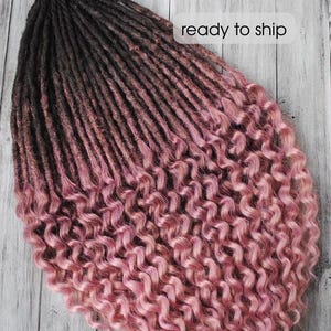 May include: A set of handmade dreadlocks with a gradient effect. The top section is dark brown, transitioning to a dusty rose pink at the mid-section, and ending in a curly, light pink texture. The text "ready to ship" is visible.