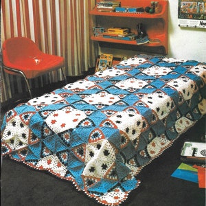May include: A blue, white, red, and black crocheted blanket with a diamond pattern. The blanket is on a bed in a room with red and white striped curtains.