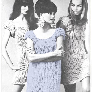May include: Three women wearing crocheted dresses. The woman in the center is wearing a light blue dress with a scoop neck and short sleeves. The women on either side are wearing white dresses with a similar style.