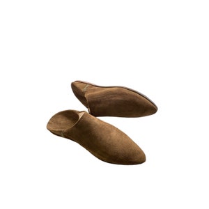 Puede incluir: Dos pares de zapatillas de piel de ante marrón con punteras puntiagudas.