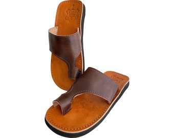Peut inclure: Une paire de sandales en cuir marron avec une bride en T et une semelle noire. Les sandales ont un design simple et sont faites de cuir de haute qualité.