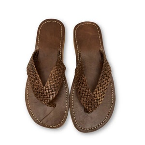 May include: A pair of brown leather sandals with a woven strap design.
