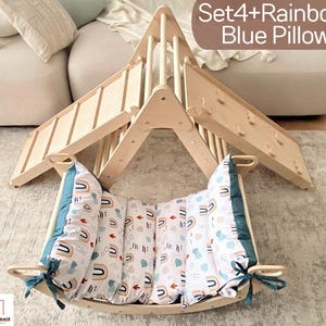 Könnte beinhalten: Holz-Kletterdreieck mit Rutsche und einem blauen Kissen mit Regenbogenmuster. Das Set ist mit "Set4+Rainbow Blue Pillow" beschriftet.