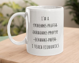 May include: White ceramic mug with black text that reads "I'm a -eknomks prufsr- eknomks profsr- ecnmks presr- I teach economics"