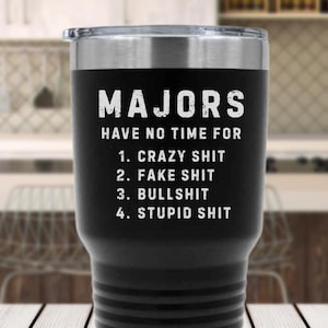 May include: Black insulated tumbler with a silver lid. The tumbler has the word "MAJORS" in white block letters, followed by a list: "HAVE NO TIME FOR 1. CRAZY SHIT 2. FAKE SHIT 3. BULLSHIT 4. STUPID SHIT."