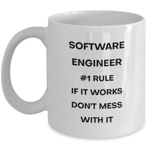 Pu&ograve; includere: Tazza da caff&egrave; in ceramica bianca con testo nero che recita "Software Engineer #1 Rule If It Works Don't Mess With It"