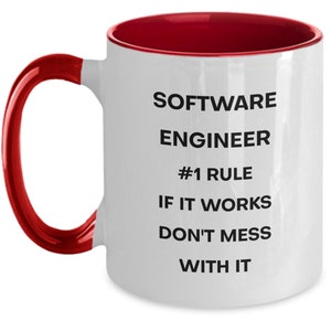Pu&ograve; includere: Tazza da caff&egrave; in ceramica bianca con bordo e manico rossi. La tazza ha testo nero che recita "SOFTWARE ENGINEER #1 RULE IF IT WORKS DON'T MESS WITH IT"