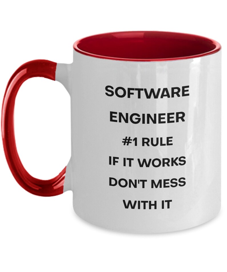 Pu&ograve; includere: Tazza da caff&egrave; in ceramica bianca con bordo e manico rossi. La tazza ha testo nero che recita "SOFTWARE ENGINEER #1 RULE IF IT WORKS DON'T MESS WITH IT"