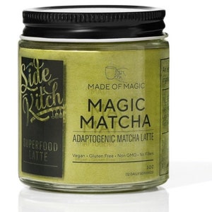 May include: A glass jar with a black lid containing green matcha powder. The label reads "Side Ritch" and "Magic Matcha Adaptogenic Matcha Latte". It is vegan, gluten-free, non-GMO, and contains no fillers. The jar contains 3 oz (112 daily servings).
