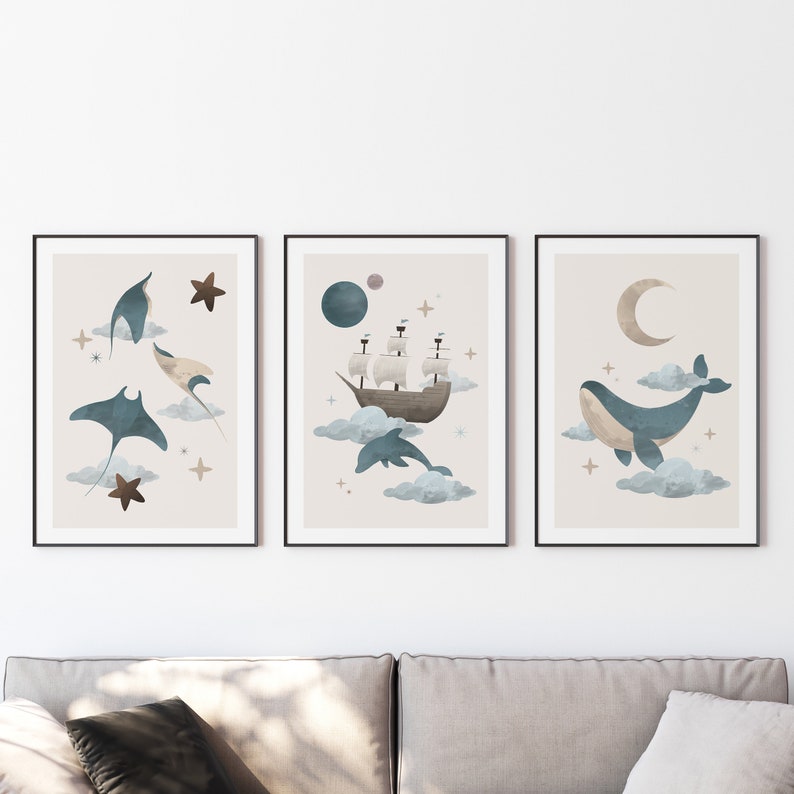 May include: Set of three framed prints with a nautical theme. The first print features a blue manta ray, the second print features a ship sailing on clouds, and the third print features a blue whale swimming on clouds.