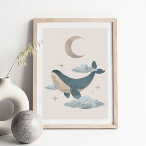 May include: A framed print with a light brown background featuring a blue whale swimming in the clouds with a crescent moon and stars.