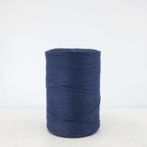 May include: A spool of dark blue cotton yarn.