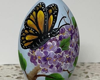 Motyl monarcha na gałęzi bzu, ręcznie malowany motyl na bzie, prezent w postaci monarchy, ręcznie malowane drewniane jajko, jajko wielkanocne, kolekcja motyli.