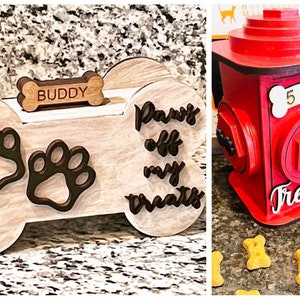 May include: Two dog treat dispensers. One is a wooden bone shape with paw prints and the text "Paws off my treats". The other is a red fire hydrant with the text "5 dogs treats".
