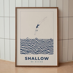 Puede incluir: Una impresión enmarcada con una ilustración minimalista de una persona buceando en agua ondulada. La impresión está sobre un fondo crema y tiene el texto "SHALLOW NO DIVING" en la parte inferior.