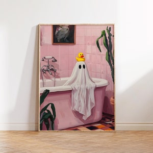 K&ouml;nnte beinhalten: Ein gerahmter Kunstdruck zeigt einen Geist, der &uuml;ber einer rosa Badewanne drapiert ist und eine gelbe Quietscheente auf dem Kopf tr&auml;gt. Das Badezimmer hat rosa geflieste W&auml;nde, ein gerahmtes Bild und eine Pflanze. Das Kunstwerk hat ein skurriles Halloween-Thema.