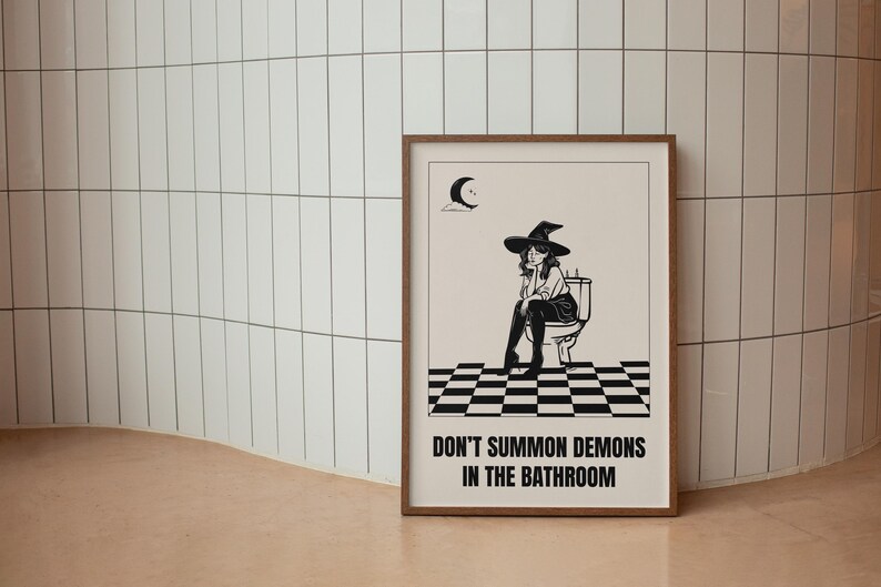 Peut inclure: Une illustration en noir et blanc d'une sorci&egrave;re assise sur des toilettes avec le texte "Ne pas invoquer des d&eacute;mons dans la salle de bain".
