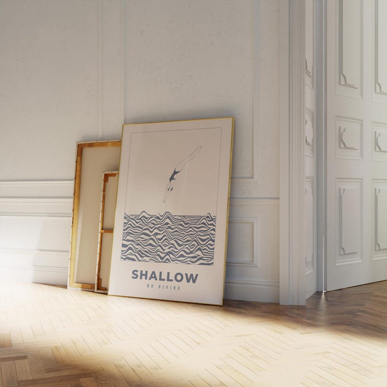 Op de afbeelding: Een ingelijste poster met een blauwe en witte illustratie van een persoon die in golvend water duikt. De poster heeft de tekst "SHALLOW NO DIVING" onderaan.