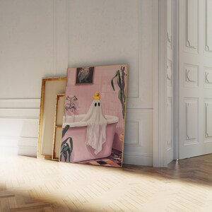 K&ouml;nnte beinhalten: Ein gerahmtes Kunstwerk zeigt einen Geist in einer rosa Badewanne mit einer Quietscheente. Der Geist ist in ein wei&szlig;es Laken geh&uuml;llt. Das Badezimmer hat rosa Fliesen und ein gerahmtes Bild.