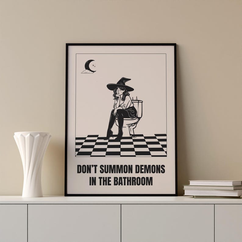 Peut inclure: Illustration en noir et blanc d'une sorci&egrave;re assise sur des toilettes avec le texte "Ne pas invoquer des d&eacute;mons dans la salle de bain".