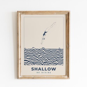 Op de afbeelding: Een ingelijste print met een minimalistisch ontwerp met een persoon die duikt in een blauw-wit golvend patroon. De tekst "SHALLOW NO DIVING" staat onderaan de print.