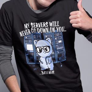 Peut inclure: T-shirt noir avec le texte "MY SERVERS WILL NEVER GO DOWN ON YOU... But I Will" et un chat de dessin animé portant des lunettes. Le chat se tient devant un rack de serveurs. La personne sur l'image fait un pouce levé.